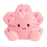 Plush toy of a pink cherry blossom by Palm Pals with purple dots, petal arms, and a gentle smiling face.
