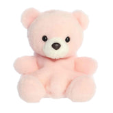 A small pastel pink bear plush with a white snout and sweet expression from Palm Pals by Aurora.