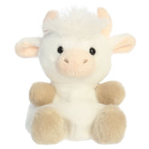 A highland cow plush toy from Aurora with fluffy white fur, tiny horns, soft hooves, and an embroidered face.