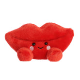 A red lips-shaped plush with rosy cheeks and a smiling face from the Palm Pals Valentine’s Collection