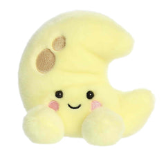 A small yellow crescent moon plush with embroidered craters and blushing cheeks from Palm Pals by Aurora.