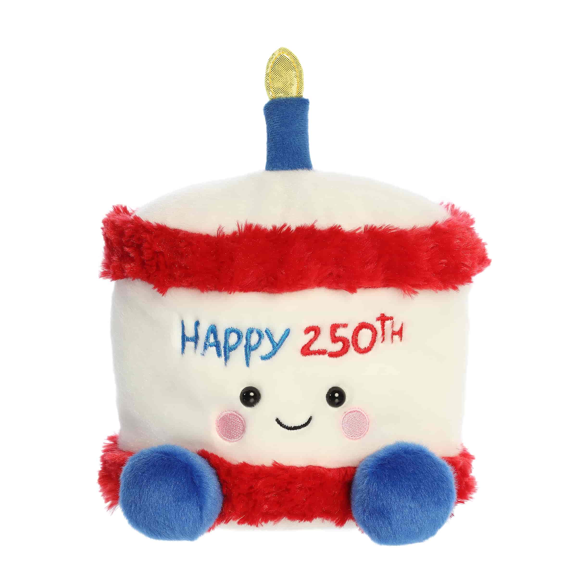 A large red, white, and blue cake plush with “Happy 250th” embroidery and a gold candle from Party-Sized Palm Pals by Aurora.