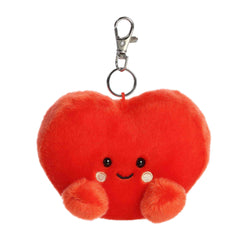 A small red heart plush clip-on with blushing cheeks and a smile from Palm Pals by Aurora.