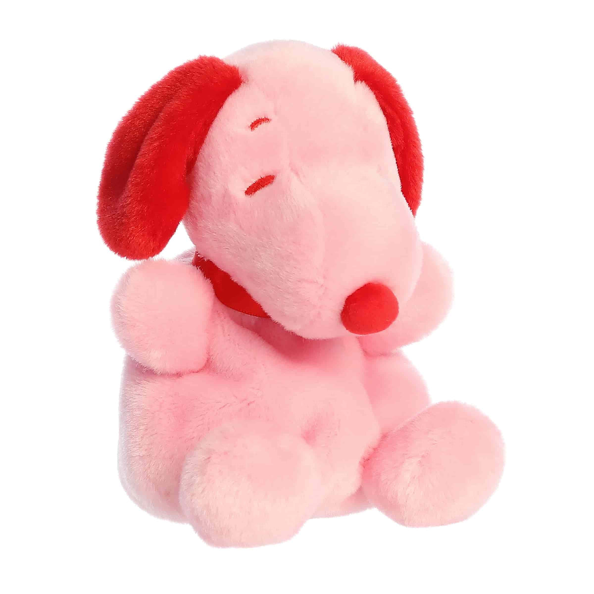 A pink Snoopy Palm Pal plush with red ears and nose from the Peanuts Valentine’s Collection
