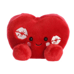 A red heart-shaped plush with kiss marks and rosy cheeks from the Palm Pals Valentine’s Collection