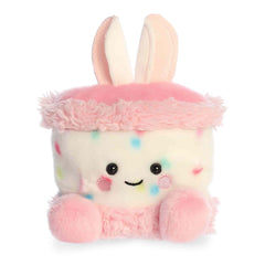 Bunny cake plush with pastel frosting colors, rounded Palm Pal shape, soft fabric body, and smiling face