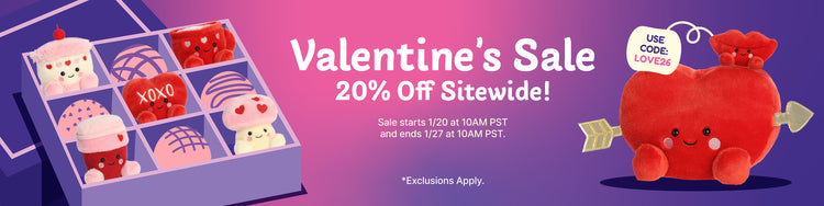 Promotional banner for Valentine's Day sale with cartoon heart-shaped candy and plush toy on a purple background.